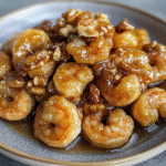 Honey walnut shrimp plated with sauce.