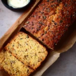 Freshly baked healthy lentil bread with seeds on a wooden board.
