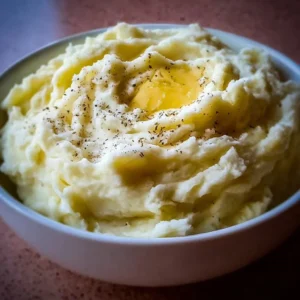 Bowl of creamy and fluffy mashed potatoes ready to be served