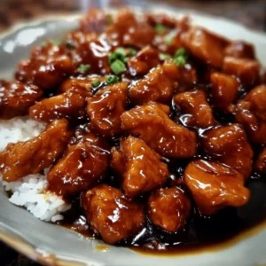 Plate of Bourbon Chicken with a rich, glossy sauce and colorful vegetables