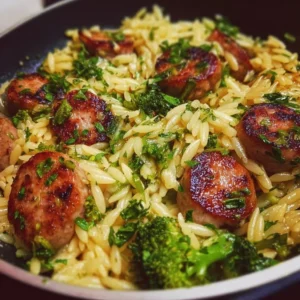 A plate of chicken sausage and broccoli orzo, garnished and ready to serve.