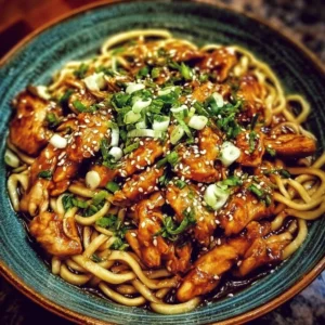 Delicious sticky garlic chicken noodles garnished with herbs and served in a bowl.